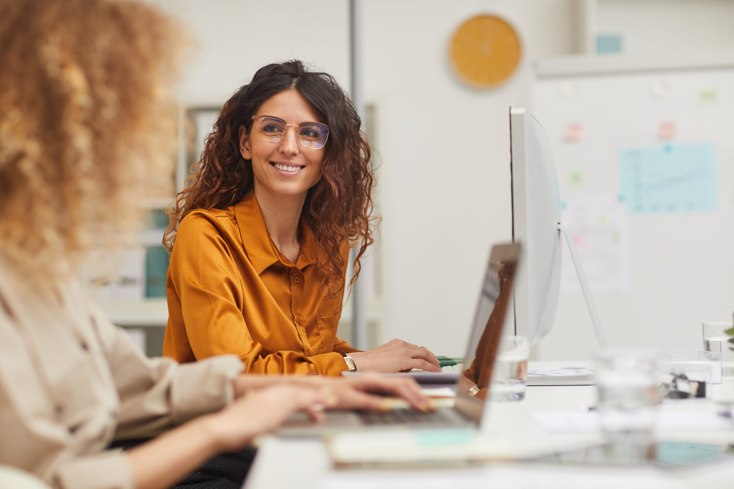 Zwei Fachkräfte arbeiten gemeinsam am Computer im modernen Büro.