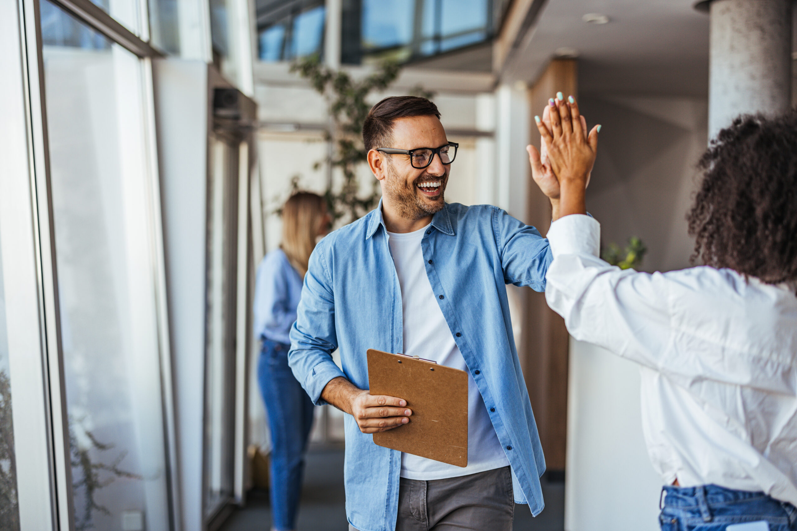 Mitarbeiter geben sich High-Five für die erfolgreiche Zusammenarbeit in der kommunalen Organisation.