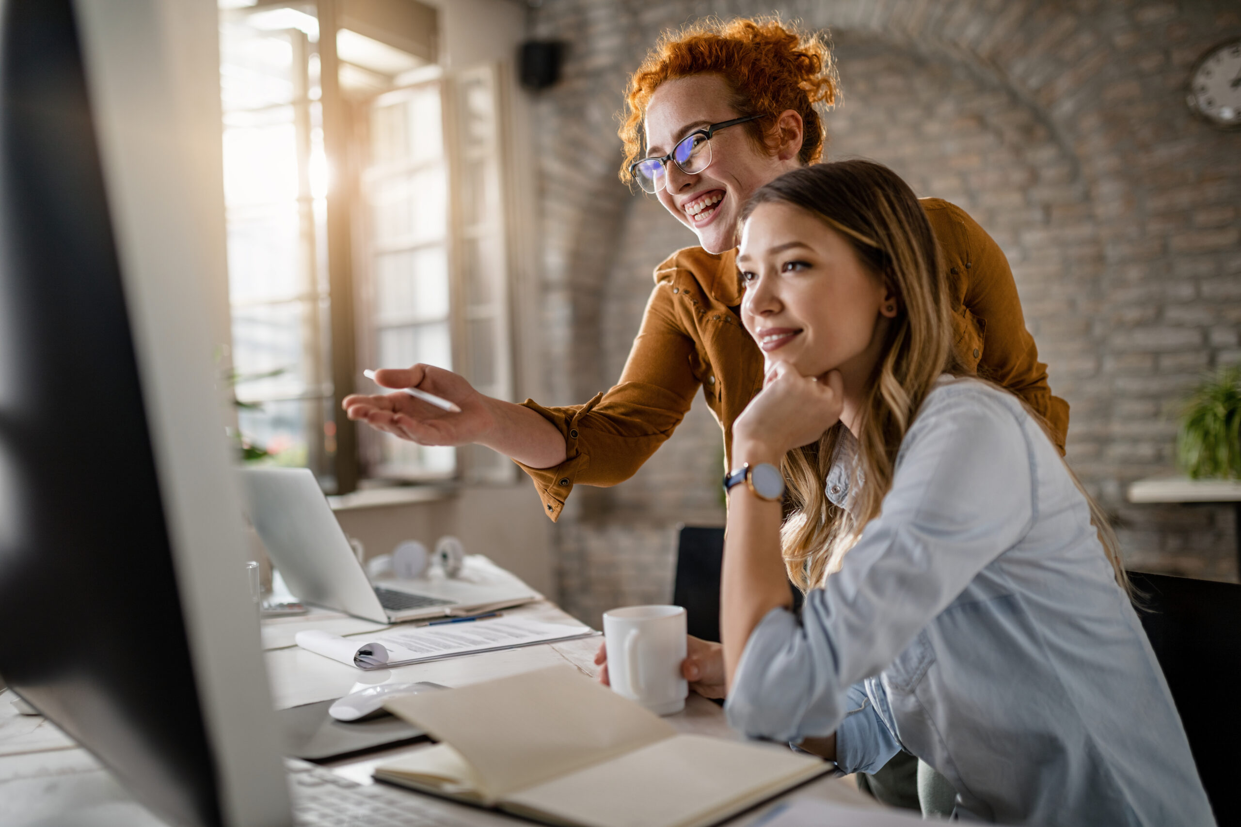 Zwei Frauen arbeiten gemeinsam am Computer.