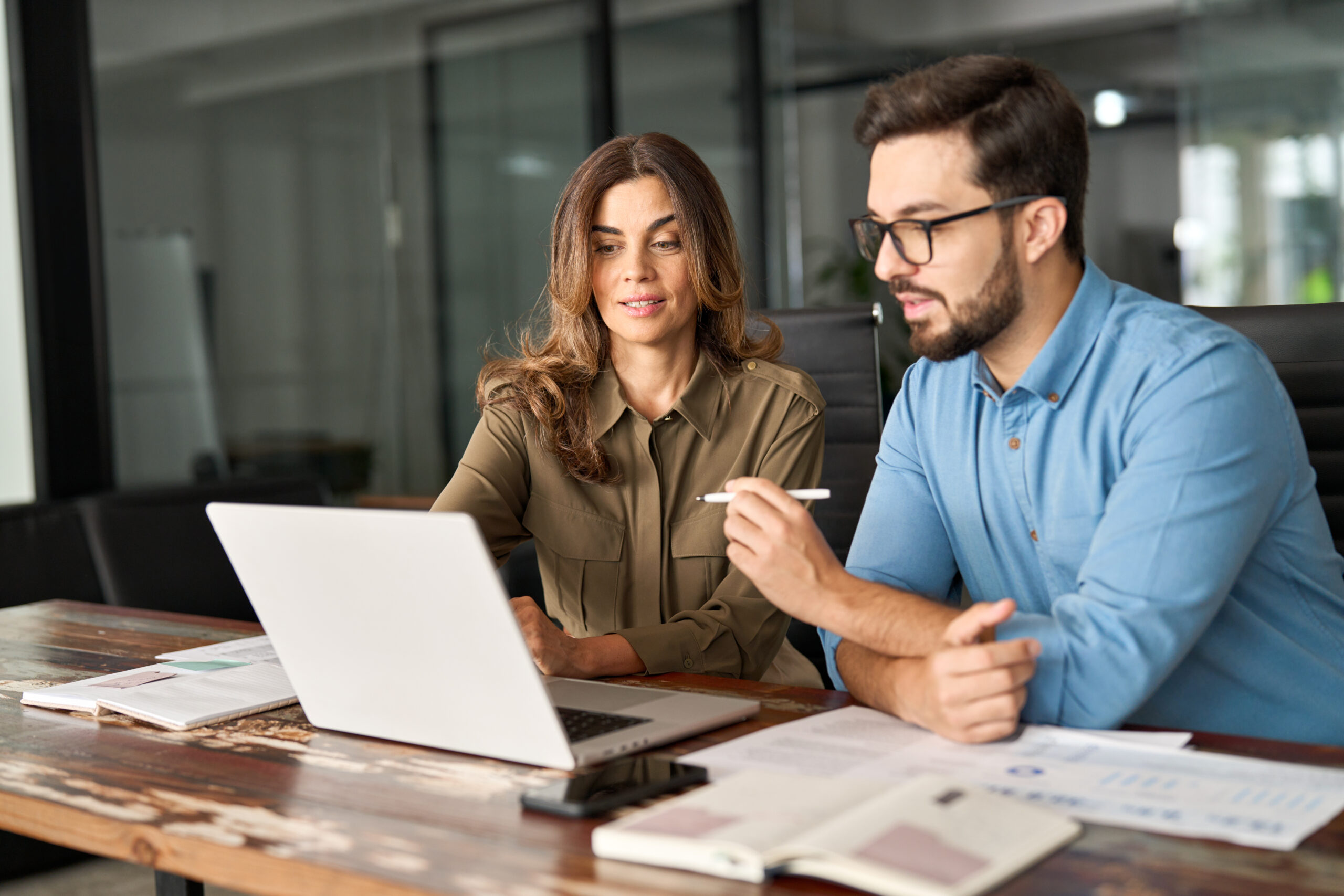Mann und Frau arbeiten gemeinsam am Laptop im Verwaltungsbüro.
